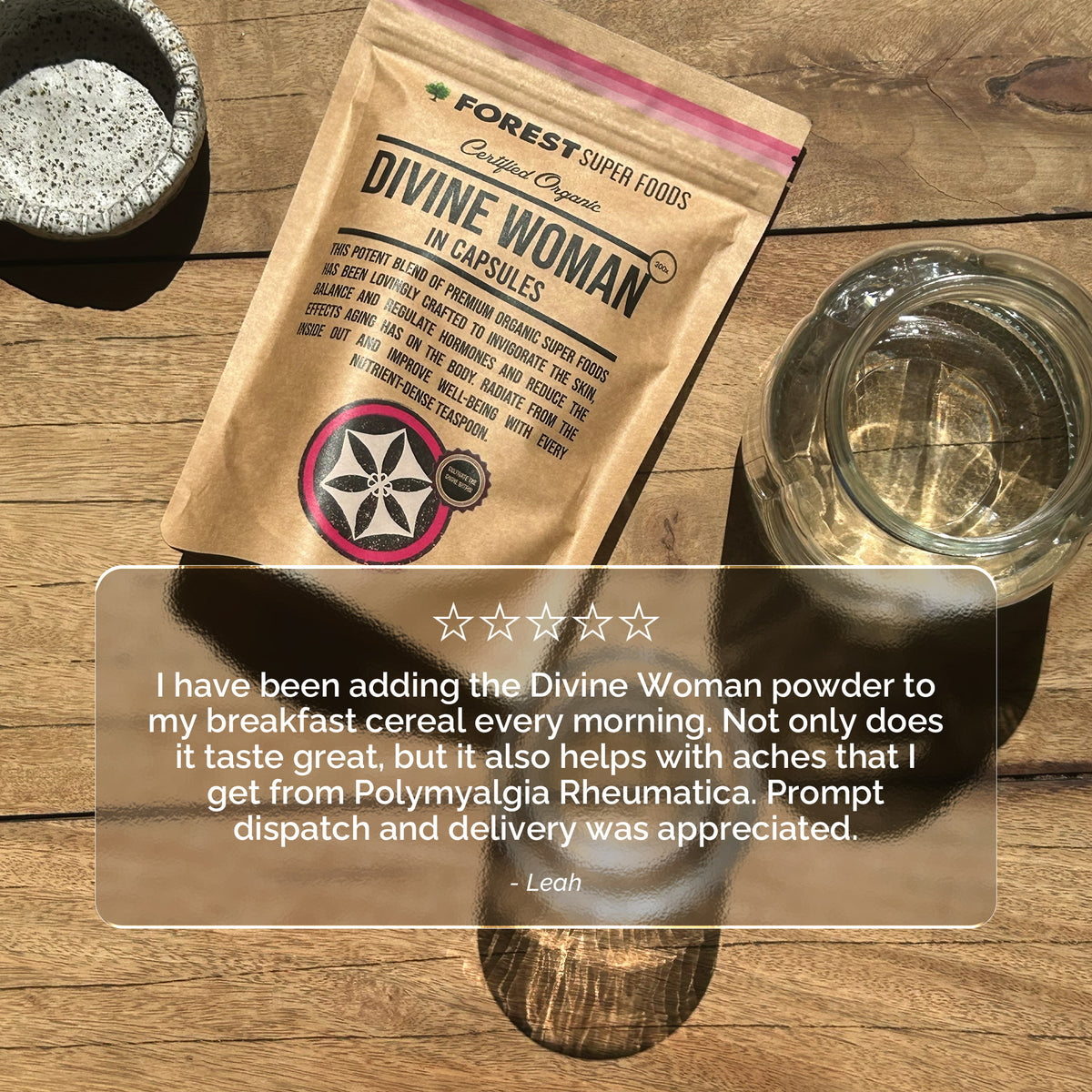 Divine Woman Multivitamin Powder in capsule packaging by Forest Super Foods shown with natural light and glass of water