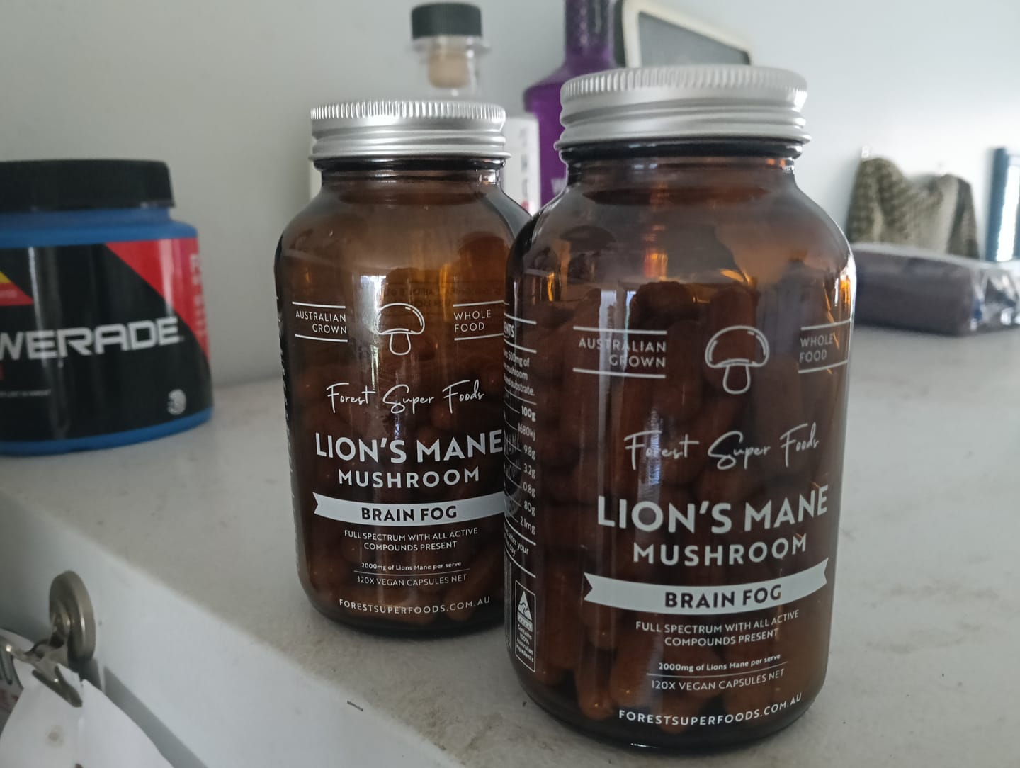 Two jars of Lions Mane Mushroom Capsules beside each other, featured in a customer review about productivity and focus.